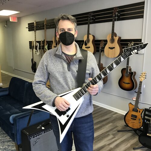 Matt holding a repaired ESP LTD Signature Alexi-200 in One Three Guitar store