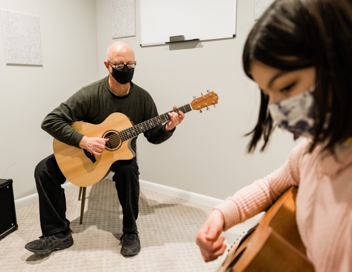 Man giving a guitar lesson at One Three Guitar | Richmond guitar shop